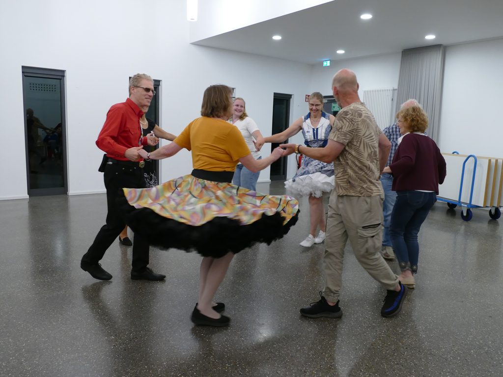8 Square Dancer tanzen mit lachenden Gesichtern im Circle